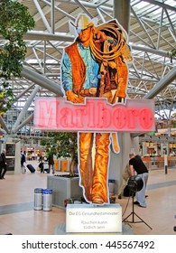 Hamburg, Germany - May 26, 2008: Marlboro Man Advertising Statue At Hamburg Airport. Socket With Writing 