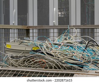 Hamburg, Germany - September 14, 2022: In The Data Center Are Old IT Network Cables And Power Cables Stored In A Lattice Box For Disposal