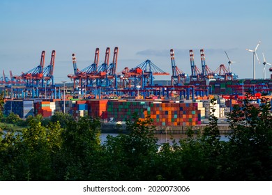 Hamburg Harbour panorama with tall cranes and colorful mixture of stacked oversea containers. High technology and automated transport and unshipping. Symbol for globalization international exchange.