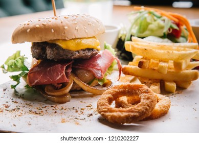 Hamburger anf fried potatoes eater human, soft drink, onion rings and salad

 - Shutterstock ID 1210202227