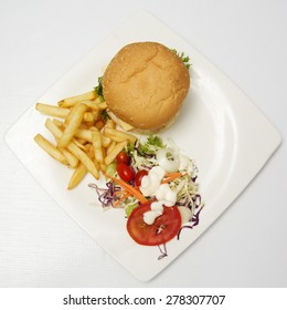 Hamburger Beef ,french Fries And Vegetable Salad On The Plate (Top View)