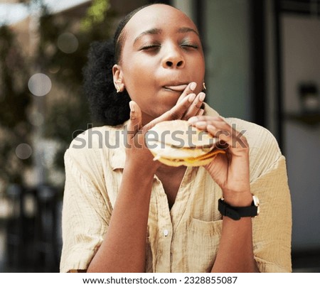 Hamburger, fast food and black woman eating a brunch in an outdoor restaurant as a lunch meal craving deal. Breakfast, sandwich and young female person or customer enjoying a tasty unhealthy snack