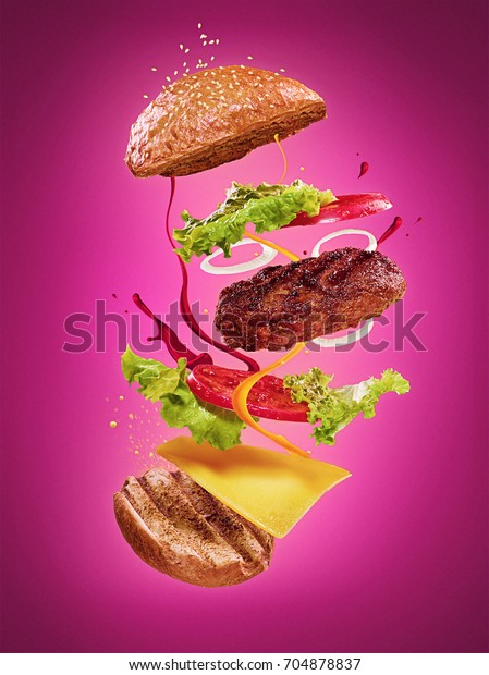 The\
hamburger with flying ingredients on lilac\
background