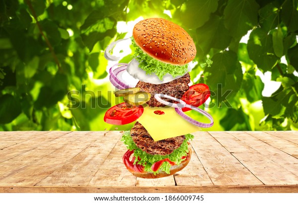 The hamburger with flying ingredients on\
summer background