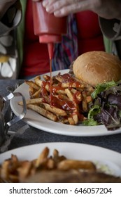 Hamburger and fries on a plate in a diner in Brooklyn, NY.