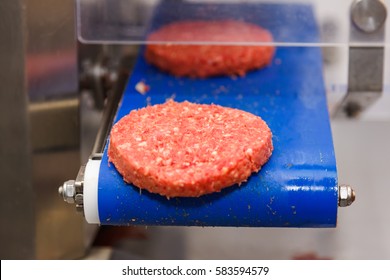 Hamburger meat on conveyor belt, meat production