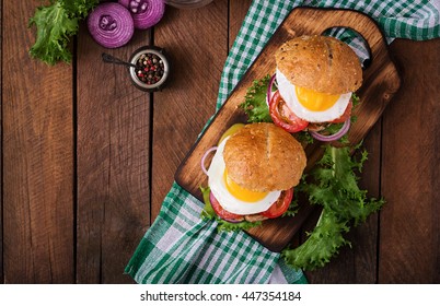 Hamburger (Sandwich) With Chicken Burger, Lettuce, Tomato, Fried Egg And Tartar Sauce. Top View