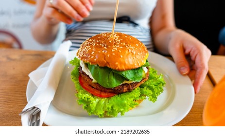 Hamburger Vegan Healthy Vegetarian Burger. Salad, Avocado, Vegetable On Veggie Sandwich Eating Cute Woman. Tasty Vegetarian Healthy Green Food