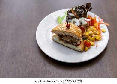 hamburger white sesame or chicken burger cut in half with vegetable and fruits salad by ripe papaya sweetcorn watermelon lettuce and dragon fruit for diet food in plate on wooden table with copy space - Powered by Shutterstock