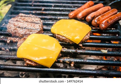 hamburgers with cheese and hot dogs on grille on camping trip