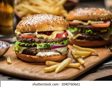 Hamburgers and French fries on the wooden tray. - Shutterstock ID 1040760661