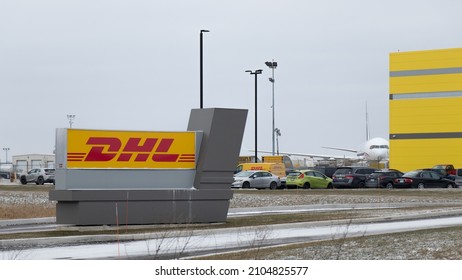 HAMILTON, CANADA - January 11, 2022: A DHL sign sits out front of a new cargo facility at Hamilton Airport; a cargo plane is seen in the background.