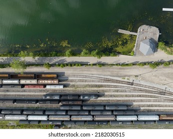 HAMILTON, ON, CANADA - July 7, 2022: A Directly Overhead, Aerial View Looking Down On Cargo, Freight Train Cars Seen Parked During The Day, At A Waterside Railyard.