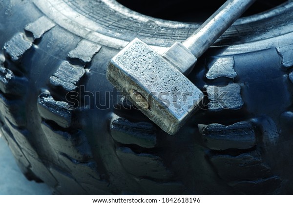 Hammer and\
car tire for strength training.\
Close-up