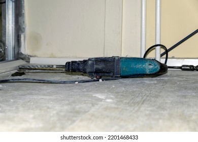 hammer drill lies on the floor in a room where repairs are being made. - Shutterstock ID 2201468433