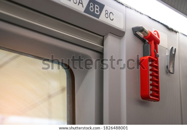 Hammer glass breaker on\
the train, tram, bus and car. Red safety glass hammer mounting or\
hanging  near the windows glass for using to break the glass in\
case accident.