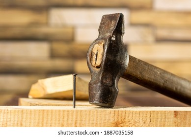 Hammer einen Nagel in ein Holzbrett, Arbeit, Tischler, Nahaufnahme eines Nagels.