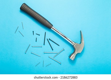 Hammer and nails close-up on a blue background. Top view.