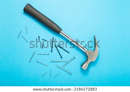 Hammer and nails close-up on a blue background. Top view.