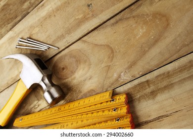 Hammer, Nails And Folding Ruler On Wood