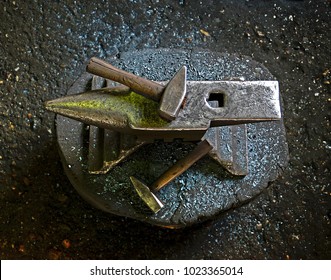 A hammer on an anvil. The tool  uses a blacksmith in a blacksmith shop