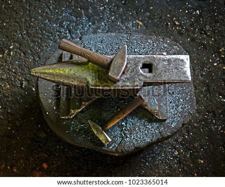 A hammer on an anvil. The tool  uses a blacksmith in a blacksmith shop