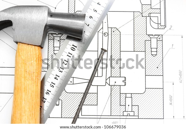 Hammer, ruler and nail on\
the drawing.