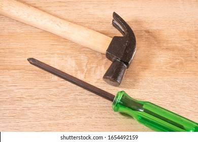 Hammer And Screwdriver On Wooden Table.