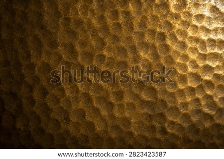 Hammered bronze, hexagonal pattern, golden metal texture, relief surface, luxury background.