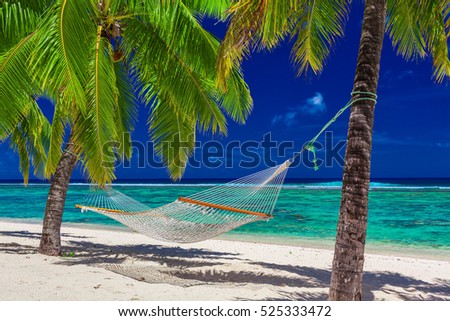 Hammock between palm trees on tropical beach of Rarotonga, Cook Islands, South Pacific