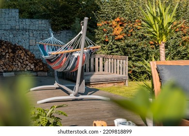 Hammock Swing In Metal Frame With Nobody On Green Lawn In Backyard Near Log House Cottage. Rest Relax Relaxation Alone On Hammock Swing In Summer Garden. Long Web Banner.
