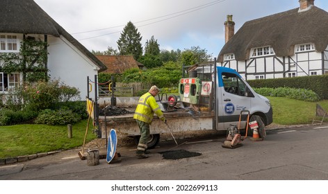 Hampshire, England, UK. 2021.  Water Company Employee Repairing The Road Surface After Filling A Hole In The Tarmac