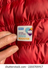 Hampshire, England, UK. 2022.  Adhesive Sticker Offered By The NHS For Having An Autumn Covid Booster Jab On A Red Padded Jacket.