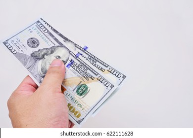 Hand with $100 banknotes stack isolated on white background