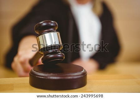Hand about to bang gavel on sounding block in the court room