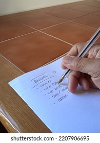 Hand In Action Photo. A Woman's Hand Writing A Grocery List.  