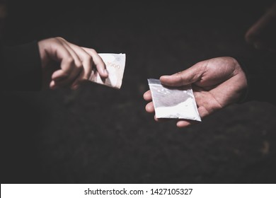 Hand of addict man with money buying dose of cocaine or heroine, close up of addict buying dose from drug dealer, drug trafficking, crime, addiction and sale concept, 