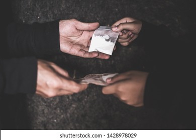 Hand of addict man with money buying dose of cocaine or heroine, close up of addict buying dose from drug dealer, drug trafficking, crime, addiction and sale concept, 