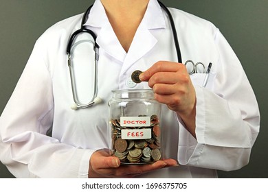 A Hand Adding A Pound Coin To A Glass Jar. Saving Money To Pay Doctor Fees Concept.