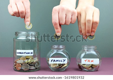 A Hand Adding A Pound Coin To An Inheritance Fund which Is distributed Between Family And Taxes. Concept.
