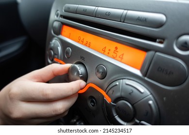 Hand To Adjust The Volume Knob Of The Car's Music Player
