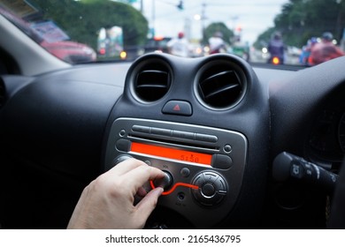 Hand To Adjust The Volume Knob Of The Car's Music Player, Car Parking On The Road