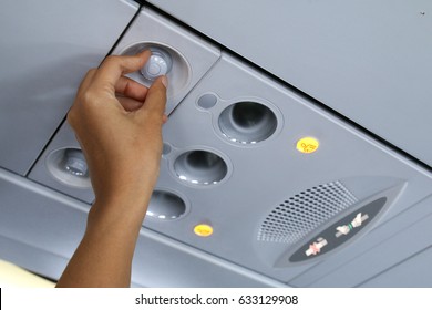 Hand adjusting air conditioning in aircraft cabin