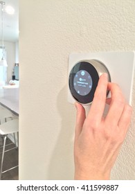 Hand Adjusting Digital Thermostat In Modern Home