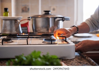 hand adjusting gas burning from a kitchen gas stove