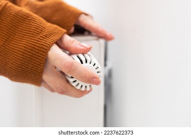 hand adjusting radiator temperature using thermostat. Home with central heating. - Shutterstock ID 2237622373