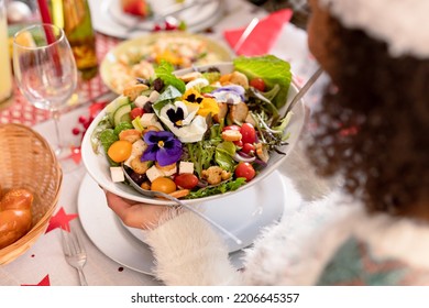 Hand Of African American Woman Holding Bowl With Salad. Christmas, Festivity And Tradition At Home.