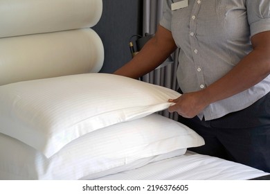 Hand of african woman maid making bed in hotel room. Housekeeper Making Bed