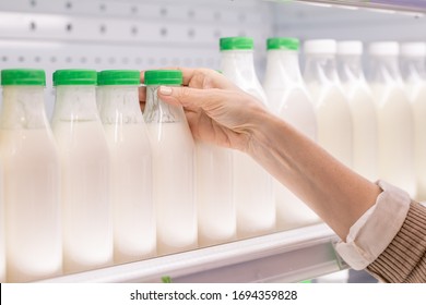 Hand Of Aged Female Consumer Taking Plastic Bottle Of Fresh Sour Dairy Drink While Choosing Food Products In Supermarket