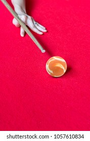 Hand Aiming The Orange Marbel Cue Ball On Red Billiard Table.